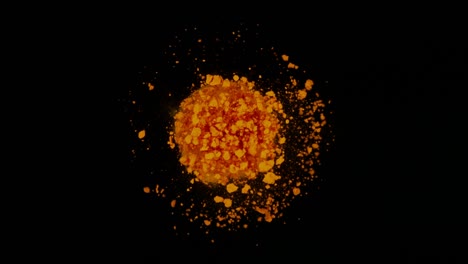 Super slow motion of colored powder explosion isolated on dark background.