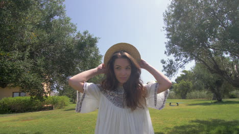 beautiful woman in a white dress and hat in a summer garden