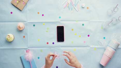 Top-view-woman-using-mobile-phone-listening-to-music-Birthday-Party-planning-hands-from-above---Red-Epic-Dragon