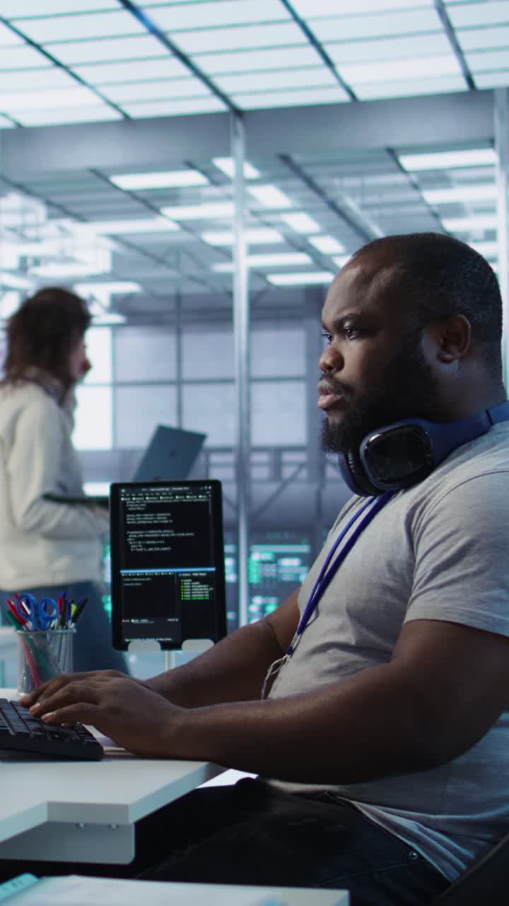 Vertical video Cheerful IT specialist monitoring high tech supercomputers using tablet