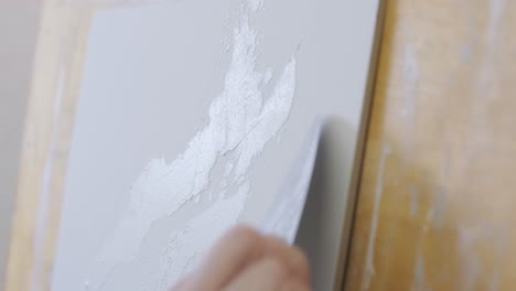 artist using palette knife to apply texture to a painting