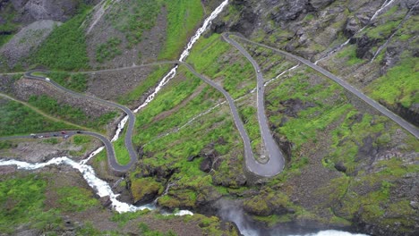 la cascada de montaña se derrama sobre los coches en el camino de los trolls