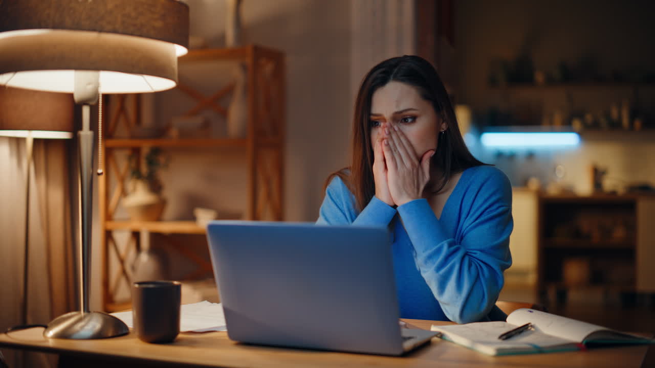 Confused lady reading laptop receiving dismissal notice late evening at home