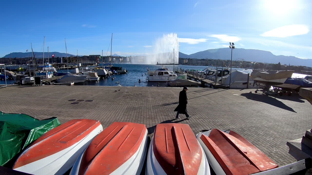 jet d'eau de genève vu depuis la rive droite, promeneur et bateaux en rade (jeto de agua de ginebra desde la orilla derecha, promeneur y barcos en rade)
