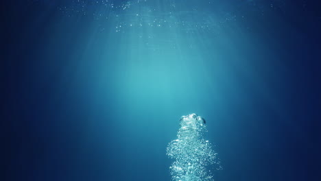 Underwater-sunlight-beams-shining-from-above-coming-through-the-deep-crystal-clear-blue-water-causing-a-beautiful-water-lighting-reflections-curtain-with-air-bubbles-rising-up-to-the-surface