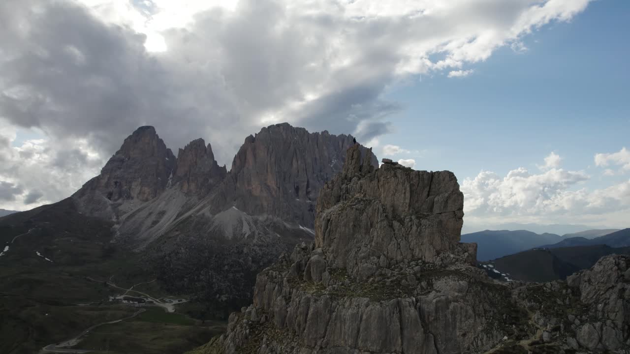 Ripresa con drone in parallasse di una persona in cima alla montagna al Passo Sella in Val Gardena, Italia.