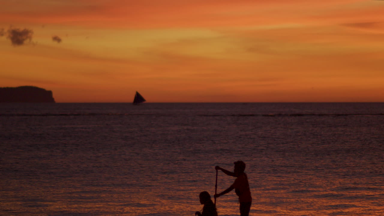 석양의 실루엣 속에서 외륜선에 탄 두 사람의 예술적 공개 사진