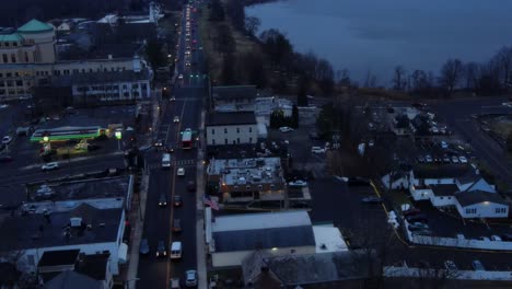 Drohnenvideo-Einer-Kleinen-Stadt-Am-See-Im-Winter-Und-Im-Herbst-Kurz-Nach-Sonnenuntergang,-Mit-Häusern-Und-Autos-Und-Einem-Bedeckten-Himmel-Und-Verkehr