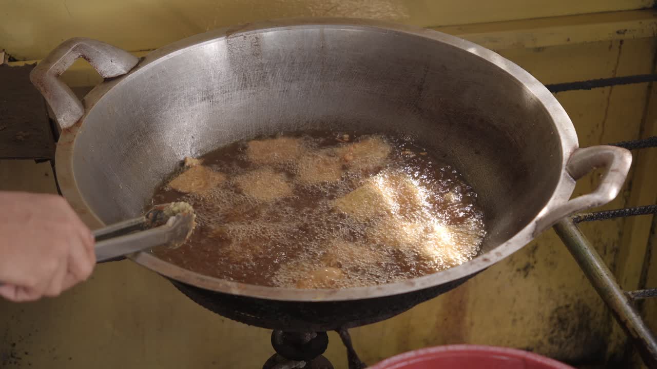 Crispy tempe frying in hot oil, showcasing traditional Indonesian street food