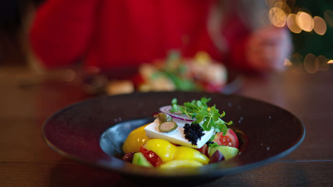 Woman in red sweater eating greek salad with vegetables