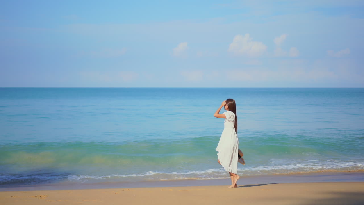 하얀 옷을 입은 아름다운 소녀가 해변을 걷는다