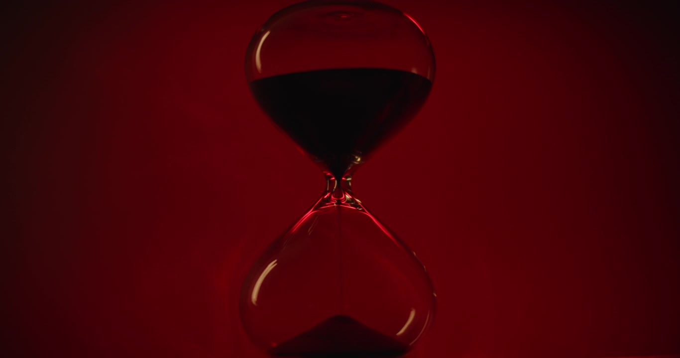Hourglass on scarlet background