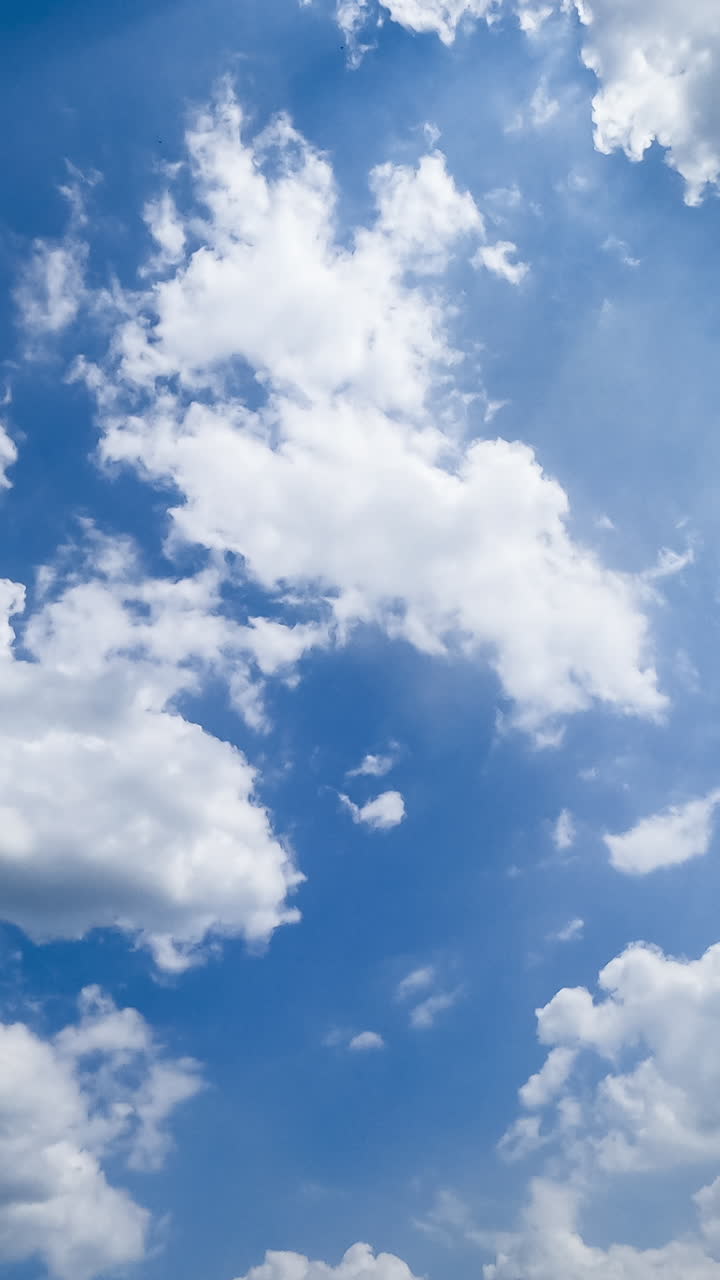 Building cloudscape on beautiful bright summer day. Light cotton clouds in the beams of sun timelapse. Vertical video