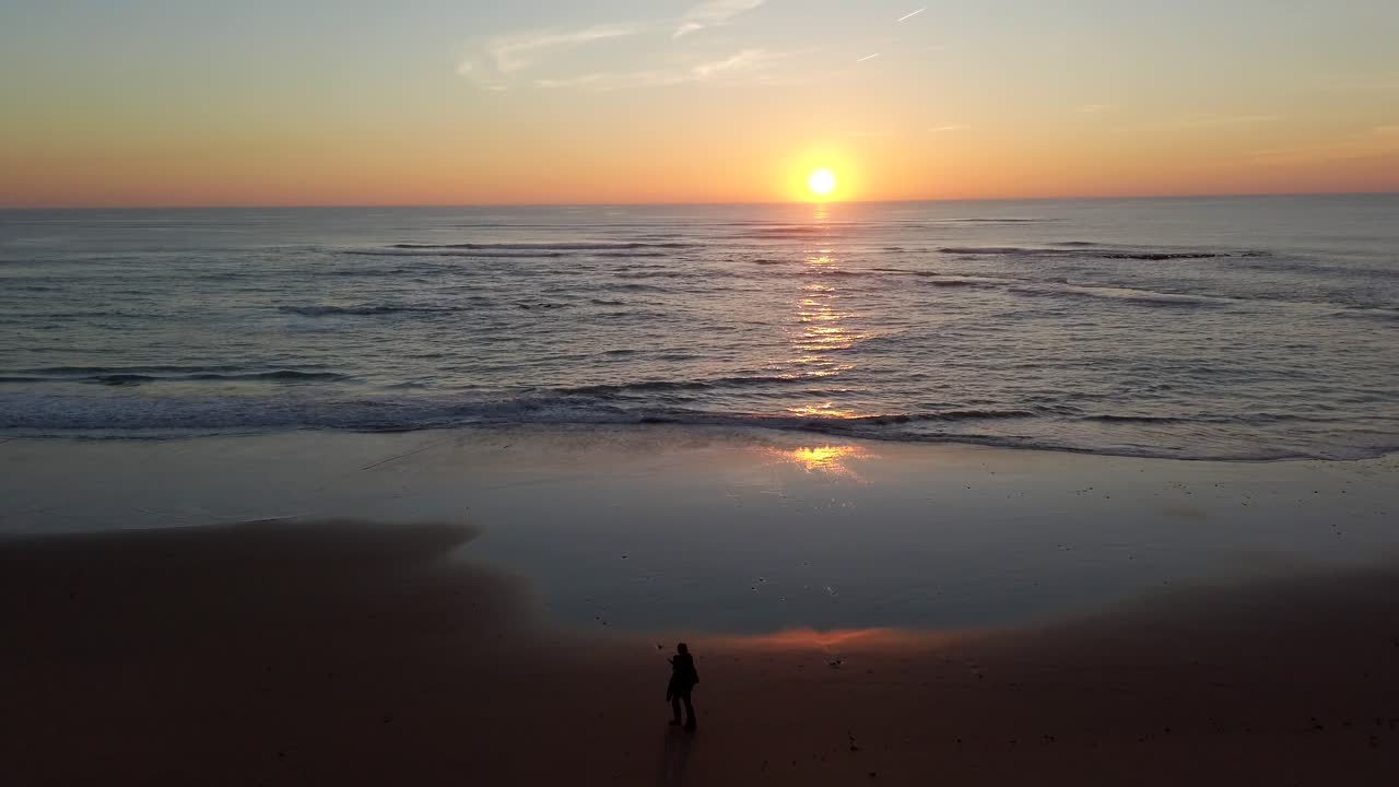 Stunning sunset coast of Cadiz city Spain, golden hour with strong sunbeam people enjoying beach