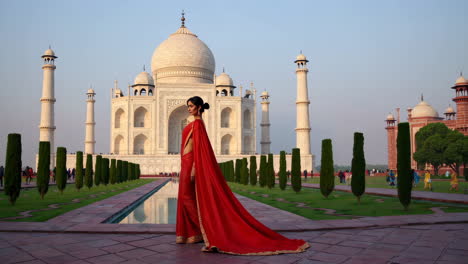 elegant woman in red sari at the iconic taj mahal