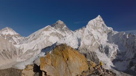 un dron revela a un turista disfrutando felizmente de la vista desde el punto de vista de kalapatthar en el campamento base del everest, nepal