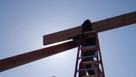 man places wood onto a-frame cabin