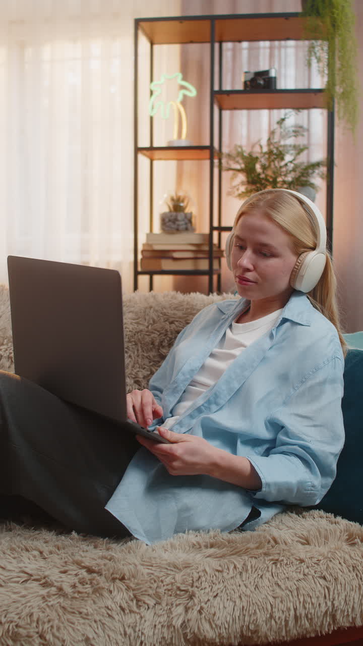 Young woman freelancer relaxed on couch laptop work cozy home comfort sunset vibe creative flow