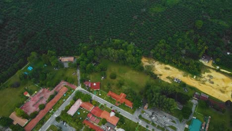 imágenes cinematográficas de drones de efluentes residenciales de molinos de aceite de palma consisten en edificios, casas, carreteras principales e infraestructura rodeadas de deforestación de árboles de aceite de palma ubicados en indonesia en full hd