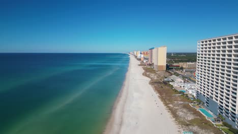 drone shot of panama city beach panning, rising, and turning to view beach on clear sunny day