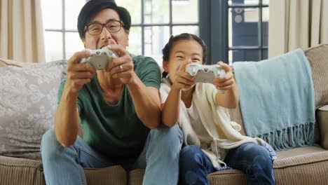 father and daughter playing video game in living room 4k