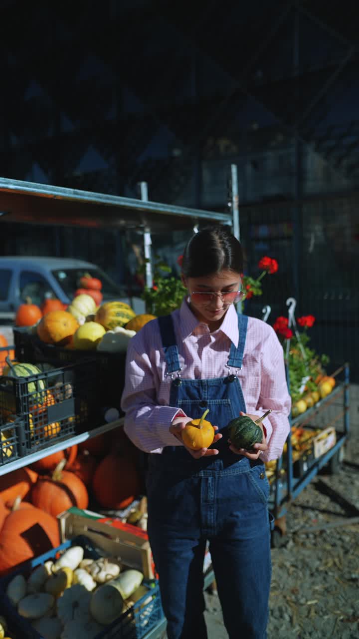 mujer en un mercado de agricultores de otoño con calabazas y calabazas