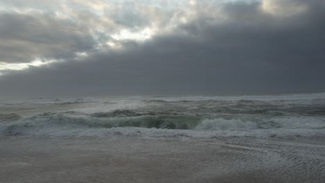 storm waves on beach at sunset