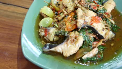 close up footage of thai hot and spicy stir fried cat fish and herbs