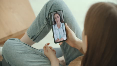 female using online chat to talk with family therapist and checks possible symptoms during pandemic of coronavirus. woman using medical app on smartphone consulting with doctor via video conference.