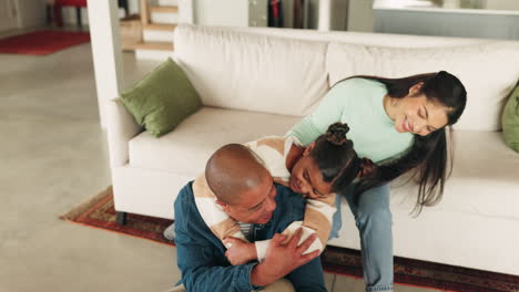 Happy-mother,-father-and-girl-hug-on-sofa