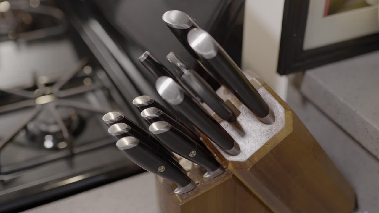 Hand taking a knife from a kitchen knife block. Kitchen knife being pulled out