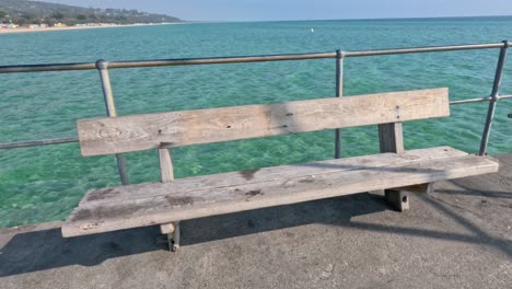 a bench on a pier overlooking the sea