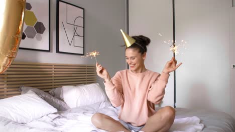 mujer con chispas en forma de estrella celebrando su cumpleaños en la cama