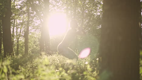 woman doing squats in a sunny forest