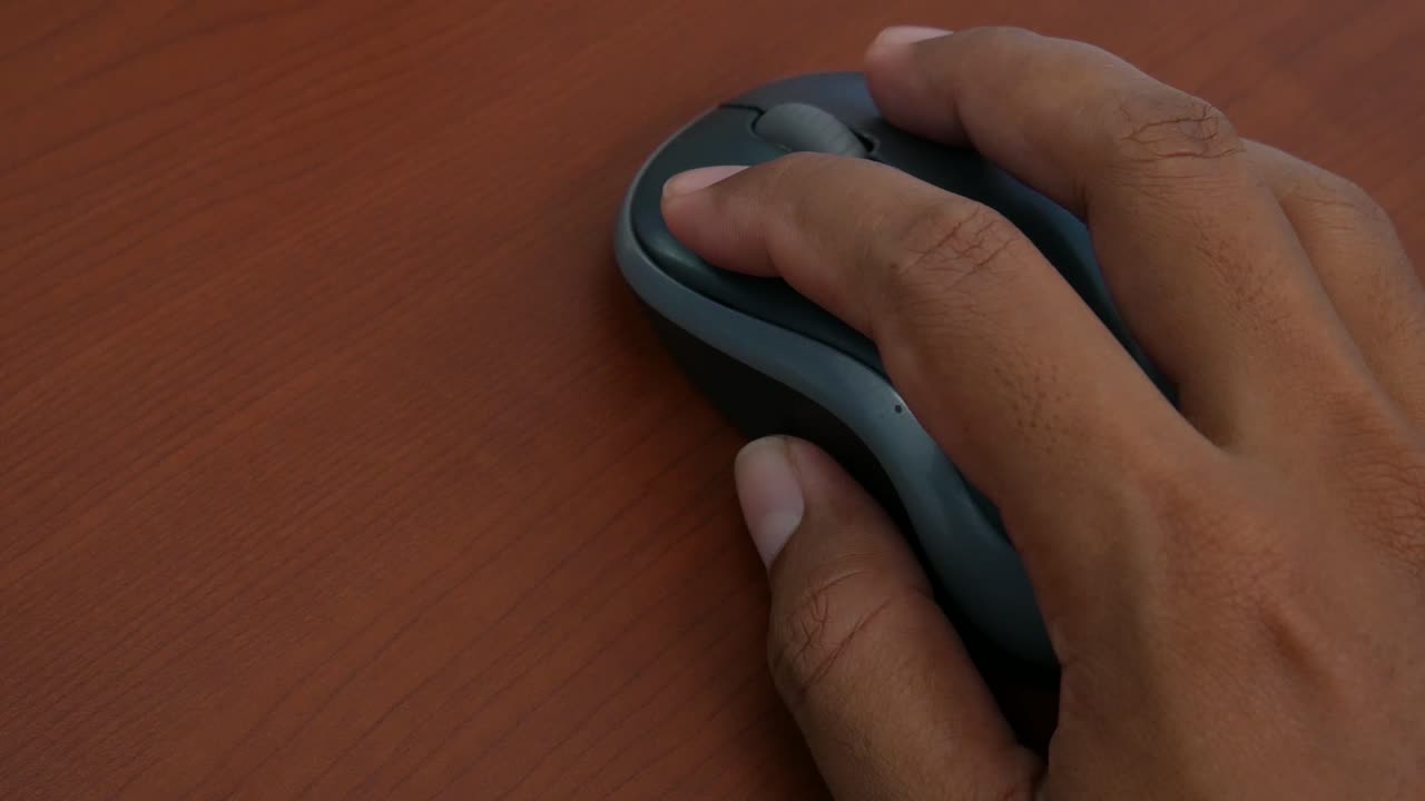 Male hand on the wireless mouse of computer
