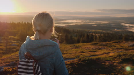 the traveler drinks hot tea on the top of the mountain admiring the sunrise on the horizon nature of