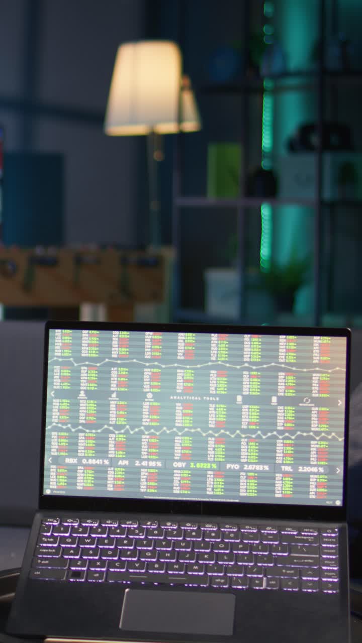 Laptop Screen Showing Stock Market Data and Financial Charts at Night