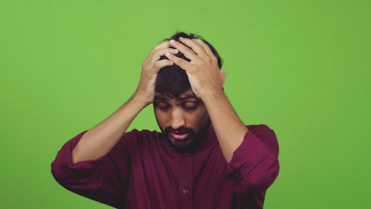 Man cannot understand how something happened, putting arms on head, isolated on green screen