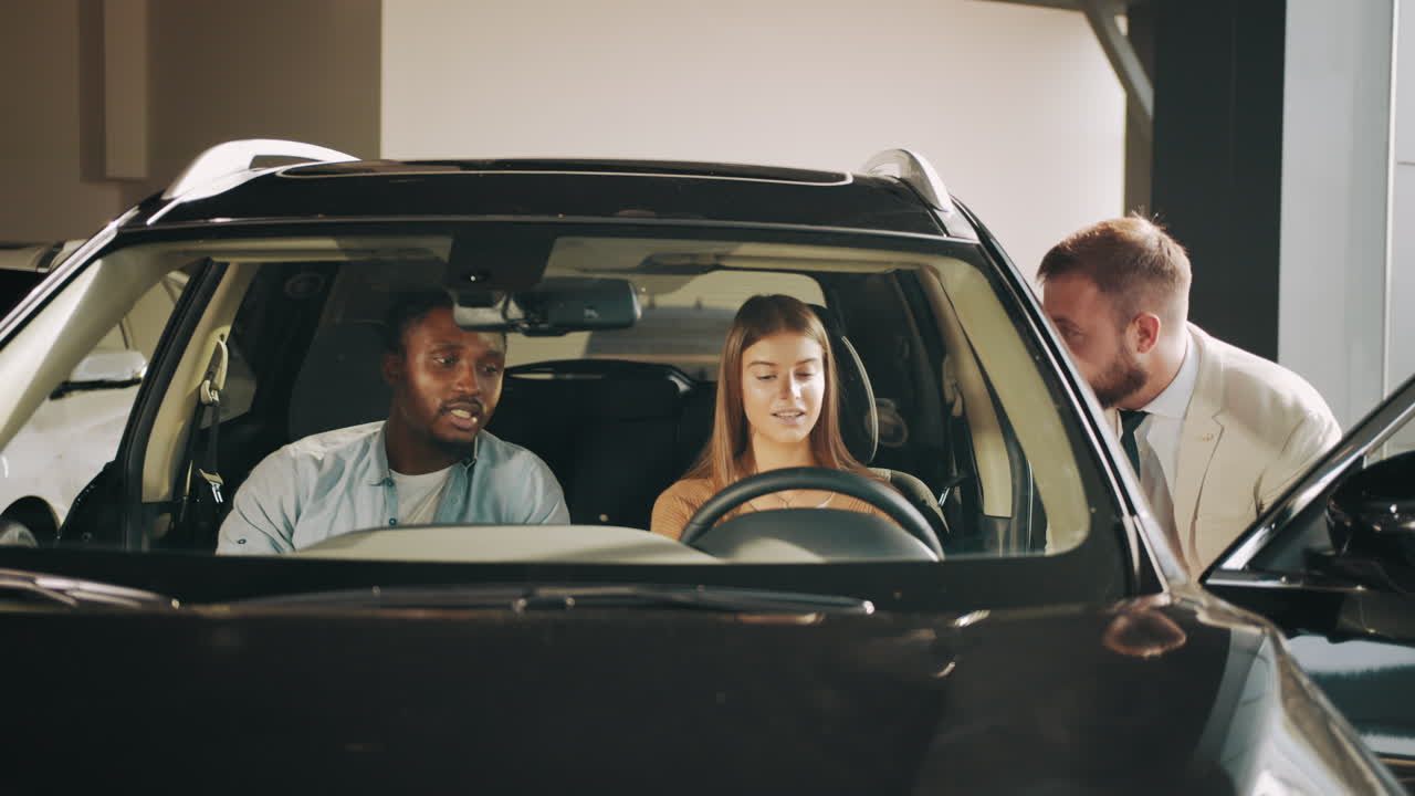 자동차 판매자 가 부부 에게 suv 를 보여주고 있다