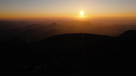 From-the-serene-embrace-of-dawn-to-the-mesmerizing-hues-of-sunset,-a-visual-journey-over-Austria's-majestic-peaks-and-valleys,-where-the-orange-light-transforms-the-scenery-into-a-surreal-dreamscape