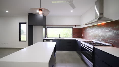 dolly along white countertops in newly built empty kitchen with black cabinets