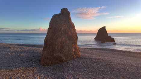 Golden-Hour-Sea-Stacks-In-Der-Späten-Abendsonne-Am-Kiesstrand-Mit-Ruhiger-See,-Kupferküste,-Waterford,-Irland