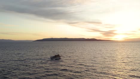 Boot-Segelt-Bei-Sonnenuntergang-Im-Malerischen-Ozean-In-Makarska,-Kroatien---Luftaufnahme-Einer-Drohne