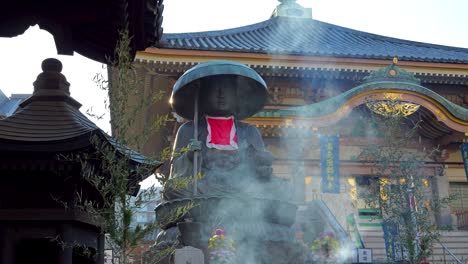 des images cinématographiques époustouflantes de la statue dans un sanctuaire japonais avec de la fumée