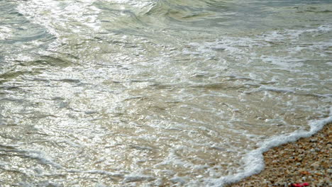 Beautiful-beach-with-waves-reaching-the-shore-of-a-white-sand-beach-on-a-tropical-during-a-sunset