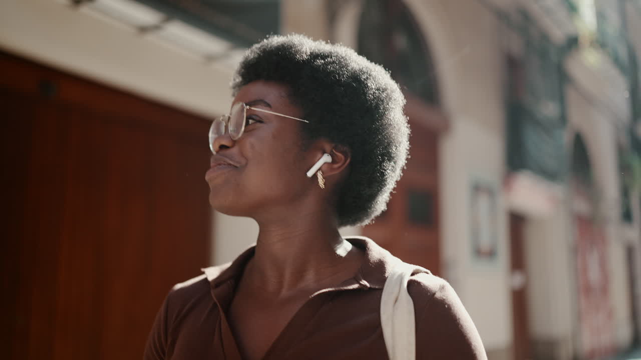 mujer joven escuchando música y caminando por la calle