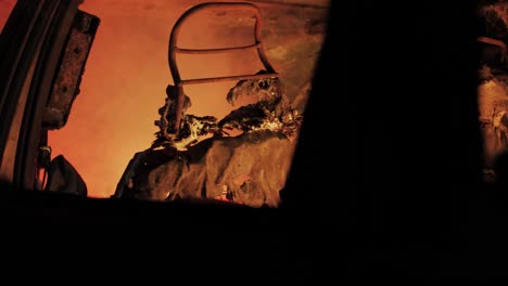 slow motion footage capturing the dramatic and haunting aftermath inside a burnt car at night