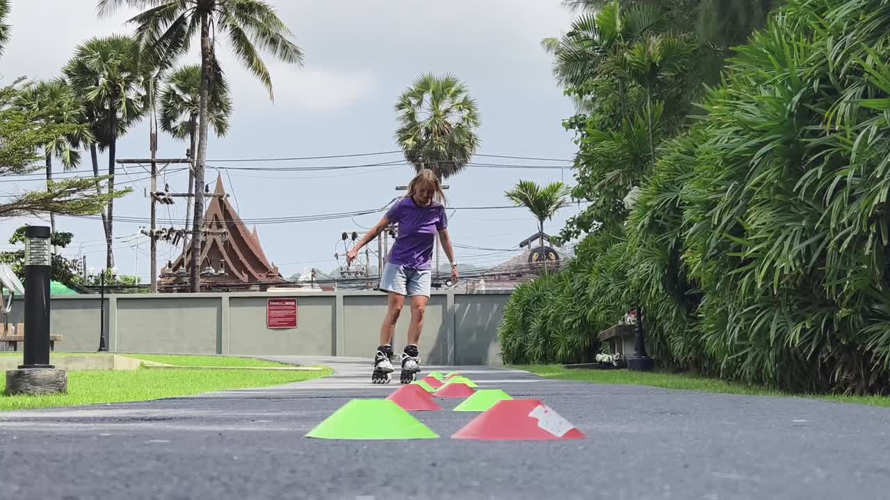 mujer patinando en un camino con conos de entrenamiento