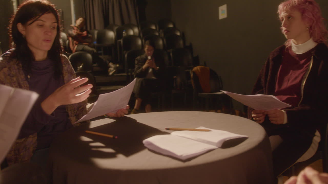 Drama Students Reading Play Scripts and Discussing Roles in Theater