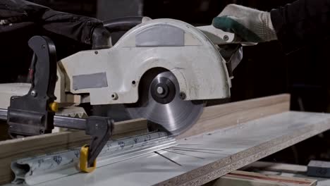 carpenter cutting metal stick with circular saw. man with table circular saw